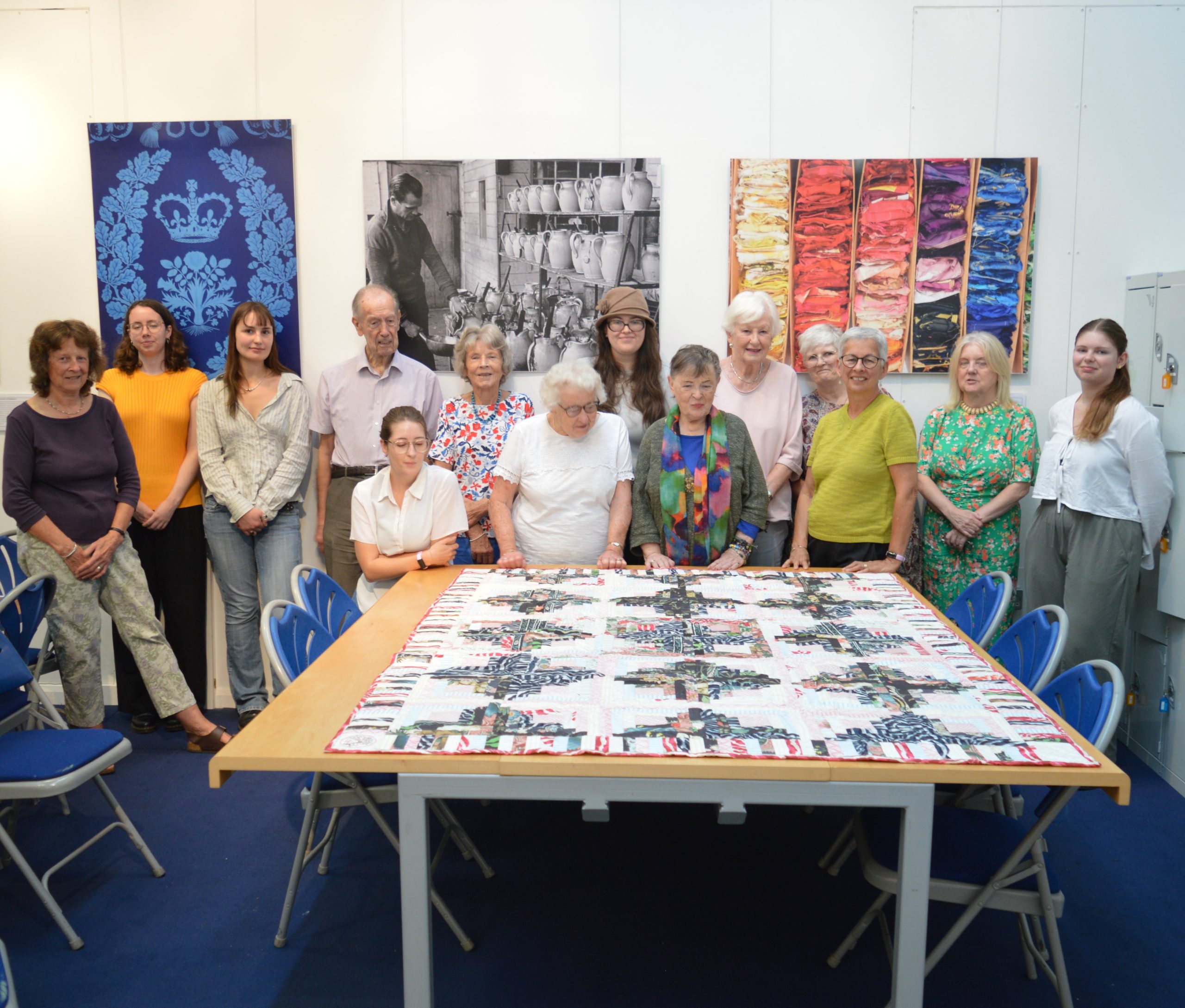 DSC_0424 Volunteers and students join Chris Helm and Mary Schoeser to celebrate the completion of the patchwork quilt